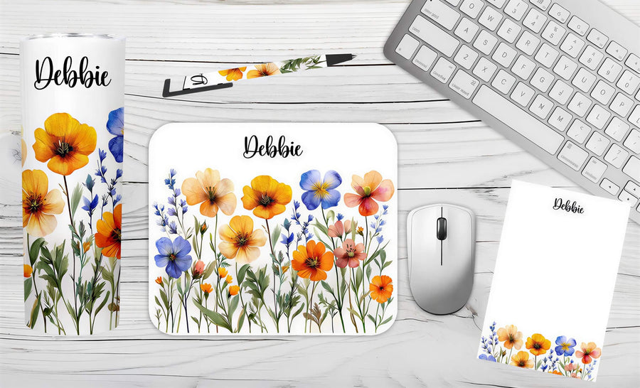 Personalized wildflower desk set featuring a tumbler, mousepad, notepad, and pen with floral designs and the name "Debbie.