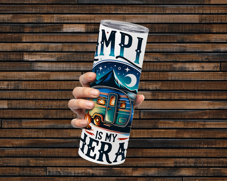 Camping Is My Therapy 20 oz stainless steel tumbler with a colorful camper design and mountain backdrop, held against a wo...