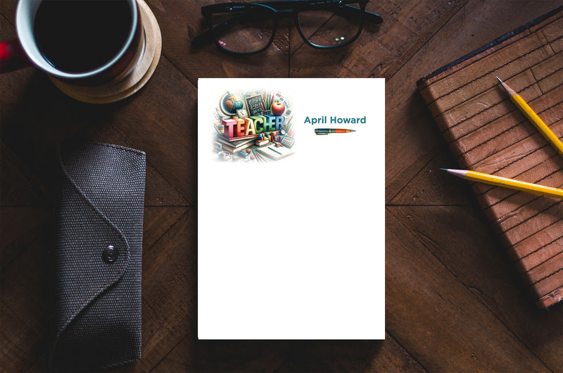 Personalized memo pad featuring "Teacher" design and the name April Howard, placed on a wooden table with glasses and a co...