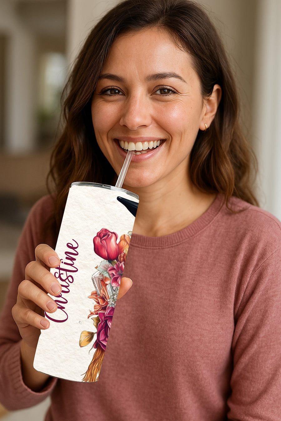 Personalized 20 oz BOHO floral graduation tumbler held by a woman with a straw, featuring vibrant flowers and the name Chr...