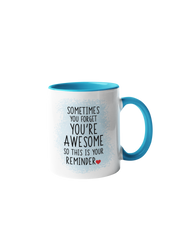 “Sometimes you forget you're awesome” coffee mug with a white body and blue handle, featuring black text and a red heart.