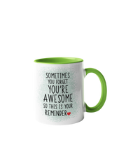 “Sometimes you forget you're awesome” coffee mug with a white body and green handle, featuring black text design.