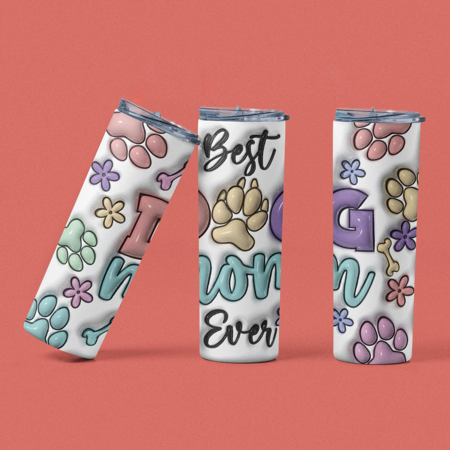 Best Dog Mom Ever 20 oz stainless steel tumbler with colorful paw prints and floral designs on a coral background.