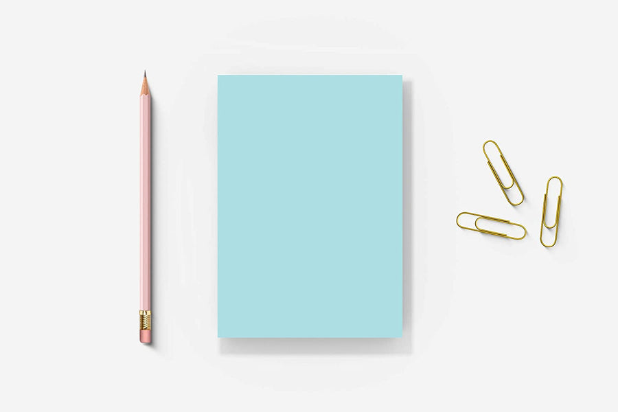 Blue memo pad, pencil and paperclips on a white background