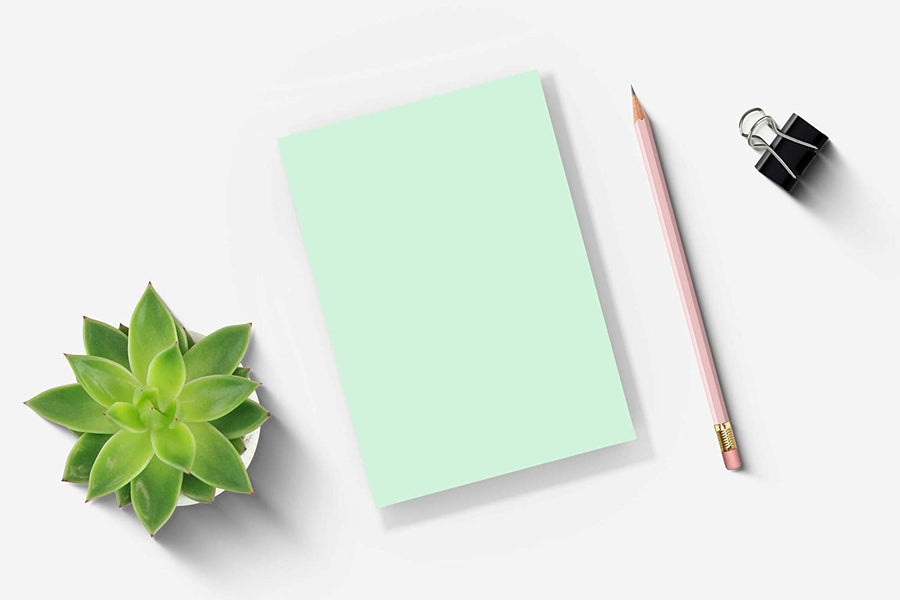 5 x 7 green blank notepads on desktop with pencil